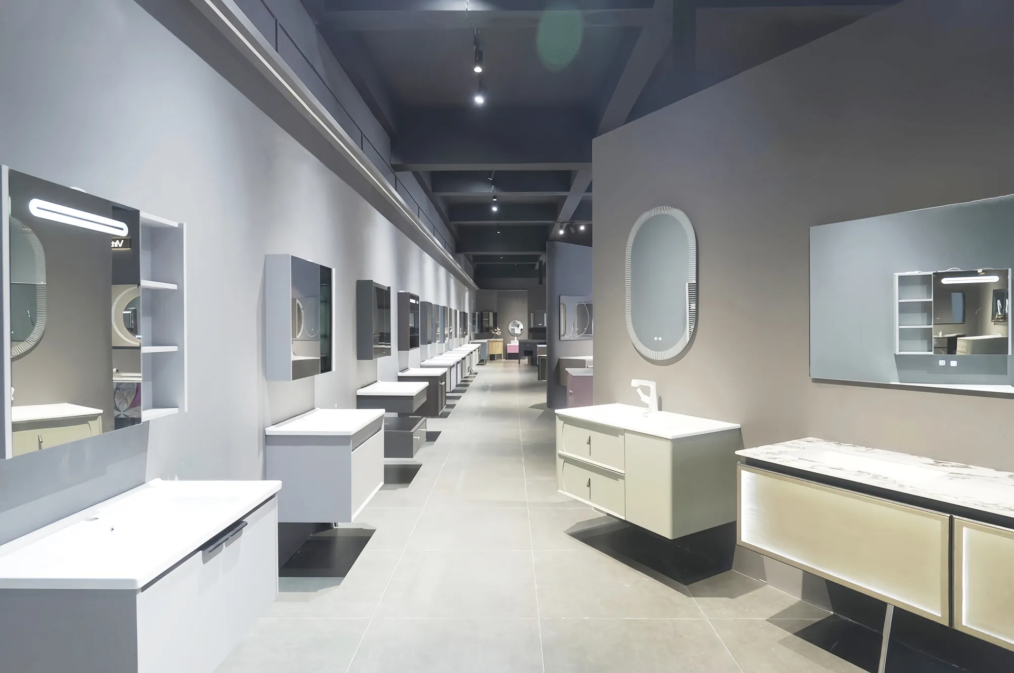 A contemporary showroom displaying a wide range of wall-mounted bathroom vanities with mirrors and integrated sinks, showcased under bright ceiling lights