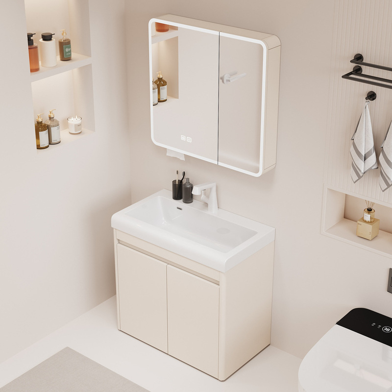Modern bathroom setup featuring a beige vanity cabinet and illuminated mirror cabinet. Includes shelves with toiletries and wall-mounted towel rack.