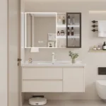 Contemporary cream-colored bathroom vanity with illuminated mirror and storage cabinet. Features minimal design and accessories.