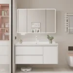 Contemporary bathroom setting featuring a white vanity unit with an illuminated mirror, decorative items, and stylish shelving.