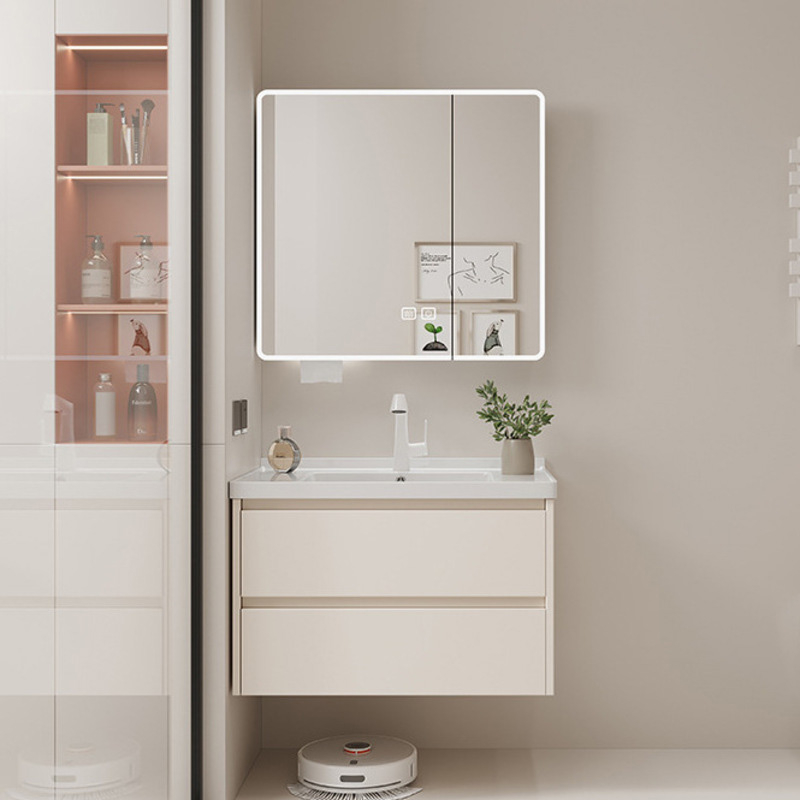 Modern bathroom vanity featuring a sleek illuminated mirror, beige drawers, and a small potted plant on a white countertop.