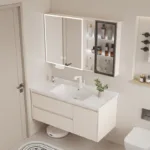 Minimalist bathroom featuring a modern vanity with sink, illuminated mirror cabinet, and shelving with toiletries.