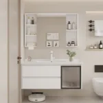 Contemporary bathroom featuring a sleek white vanity with integrated sink, mirror cabinet, shelves with toiletries, and decorative items.