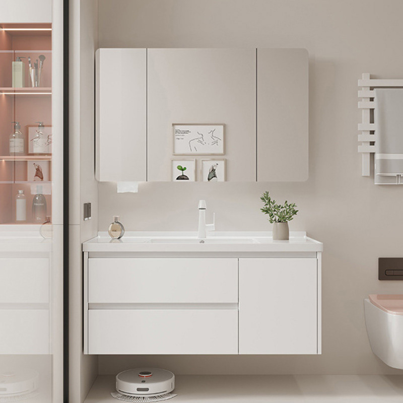 Sleek white bathroom vanity with integrated sink and mirror cabinet, surrounded by modern decor including shelves and a robotic cleaner.